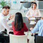 Team diskutiert gemeinsam Aufgaben und zeigt kommunikative Soft Skills im Arbeitsalltag