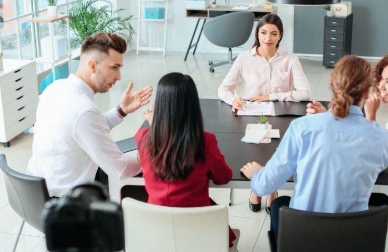Team diskutiert gemeinsam Aufgaben und zeigt kommunikative Soft Skills im Arbeitsalltag